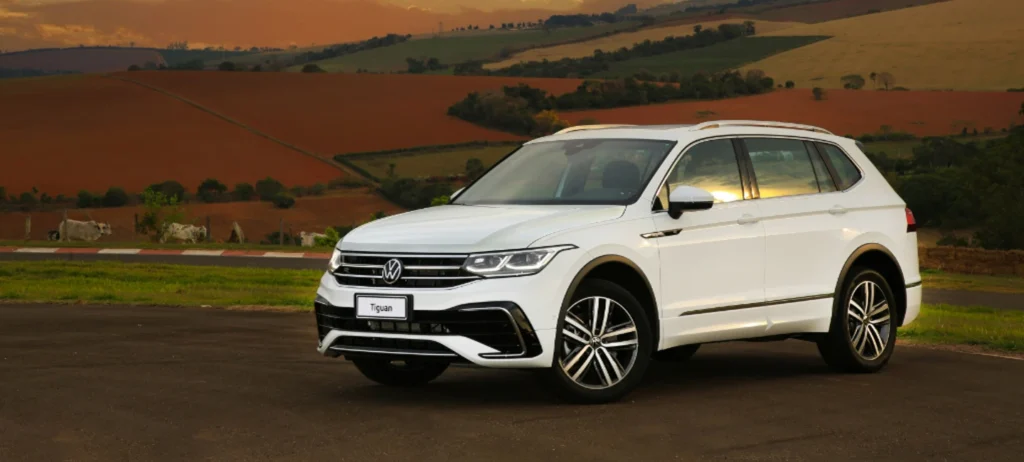 Um carro brancode quatro portas parado em meio a natureza