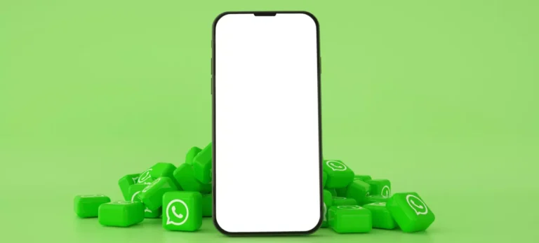 Um celular com a tela em branco é rodeado por pequenos blocos verdes com o logo do WhatsApp. Atrás, um fundo verde claro.