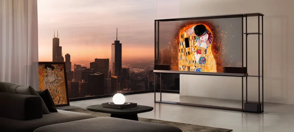 A TV OLED Signature T, da LG Eletronics, está numa estante em uma sala de parede branca. Em frente à TV, há um sofá. Do lado esquerdo, uma janela mostra a paisagem da cidade de Nova York. 
