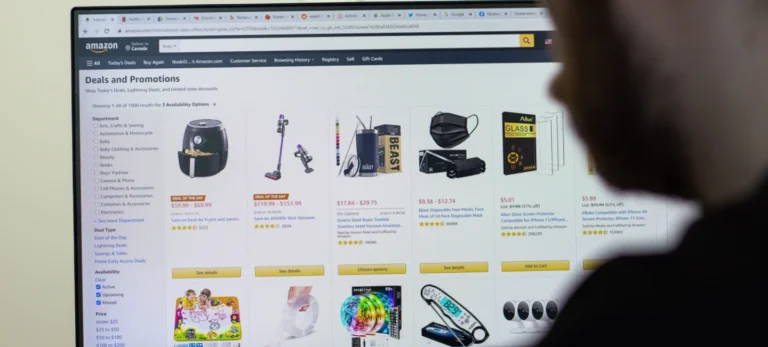 Um homem observa a tela do marketplace da Amazon com vários produtos.