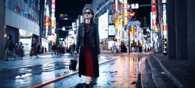Captura de vídeo gerado pelo Sora, ferramenta de IA generativa da OpenAI, que mostra uma mulher elegante em um vestido vermelho e usando óculos de sol andando à noite por uma rua em Tóquio.