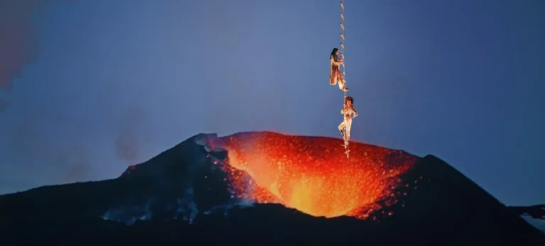 Duas mulheres estão penduradas em uma escada acima de um vulcão em erupção, em nova campanha do Pinterest.