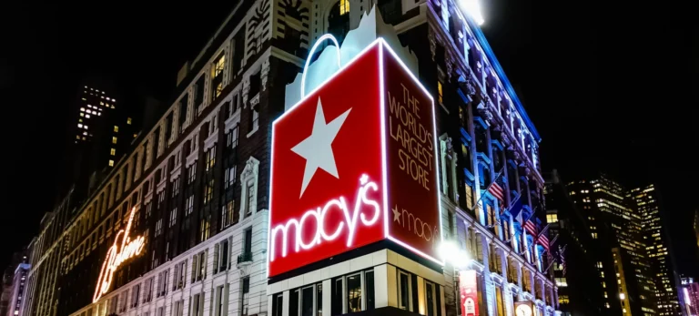 Foto mostra fachada da loja da Macy's em Nova York iluminada durante a noite.