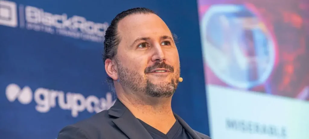 Dr. Michael Barbera, no Consumidor Moderno Experience Summit. Vemos o rosto do especialista, usando um microfone. Ele está com o cabelo preso, e usa uma cura barba e bigode.