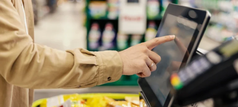 Um homem finaliza o pagamento de sua compra no supermercado em um caixa de autoatendimento.