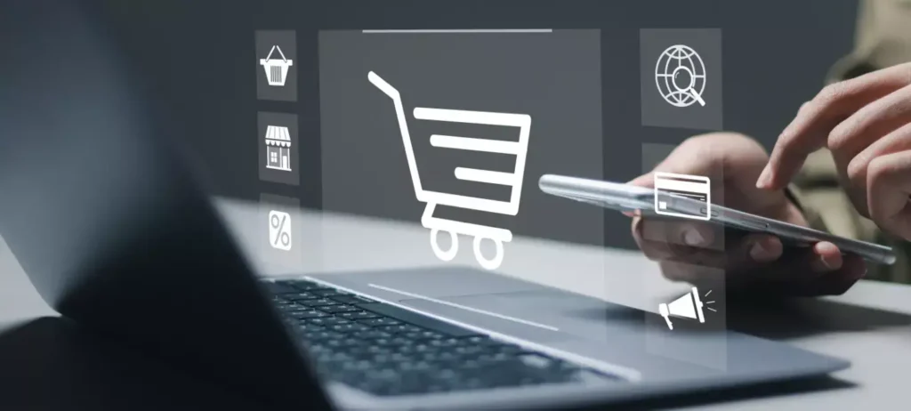 Uma pessoa digita no smartphone e uma logo de carrinho de compras aparece sobre o notebbok.