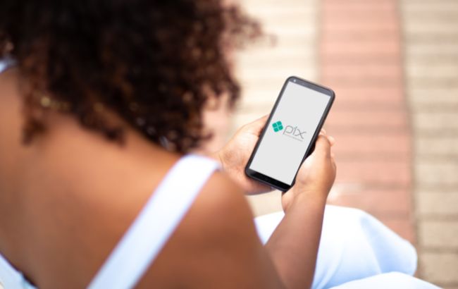 Mulher olhando para o aplicativo do PIX