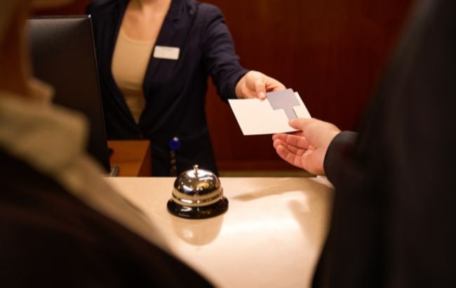 mulher ajudando homem a fazer check-in em hotel